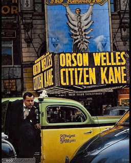 Historic Citizen Kane movie theater marquee with yellow taxi cab parked outside on city street