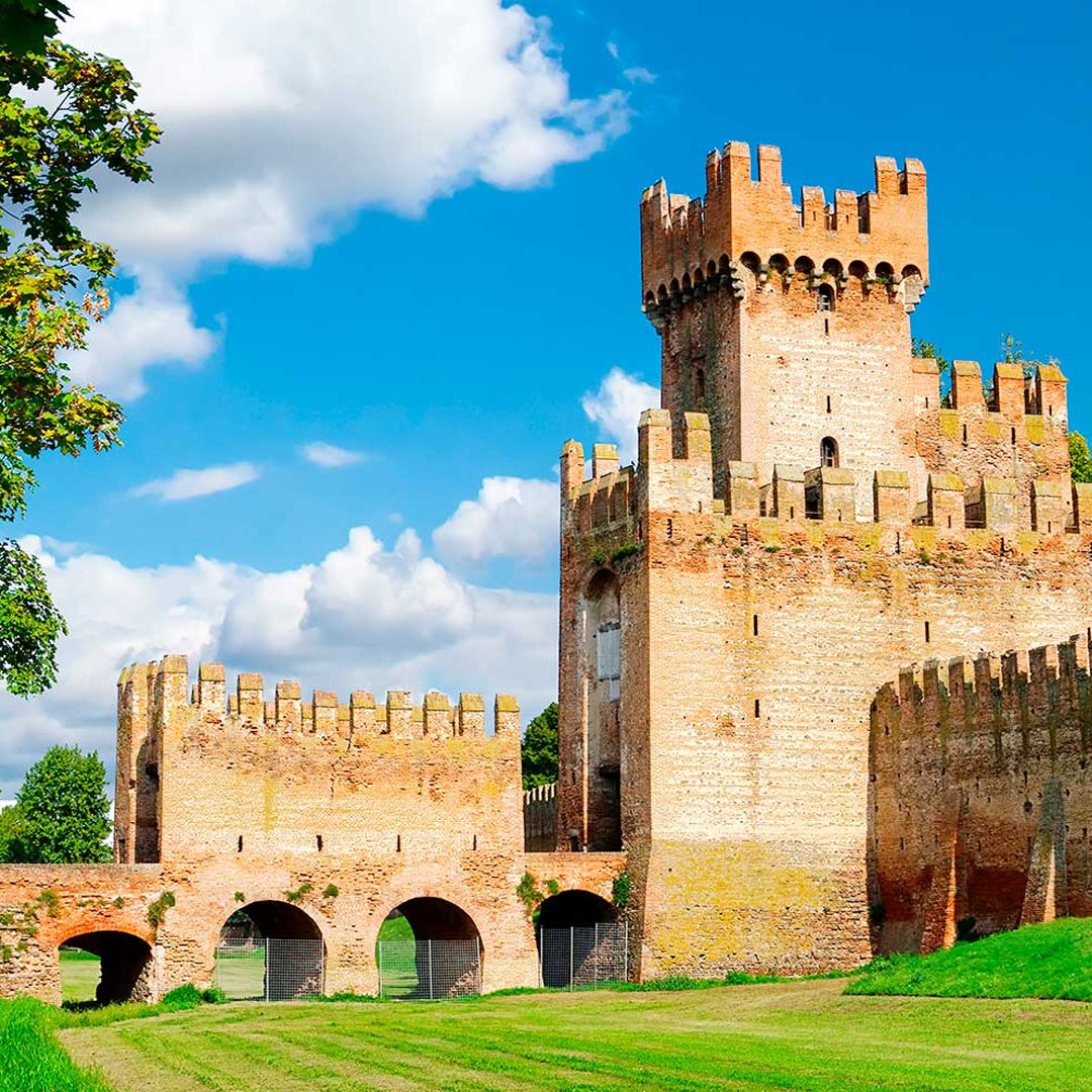 Medieval stone castle with tower and fortified walls under blue sky
