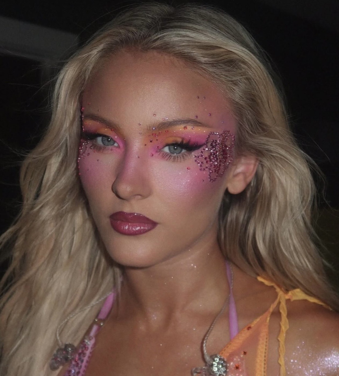 Zara Larsson with pink and orange flower-themed makeup and glitter