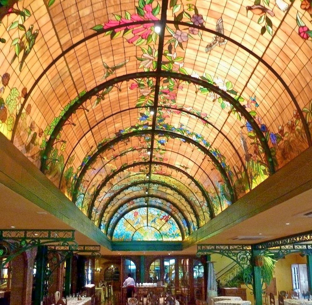 Ornate barrel vault ceiling with colorful stained glass panels in repeating arched pattern