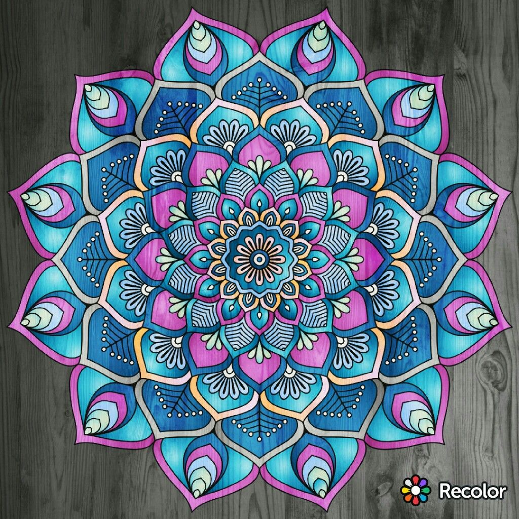 Colorful mandala with intricate floral geometric patterns in blue, purple and pink tones on wood texture