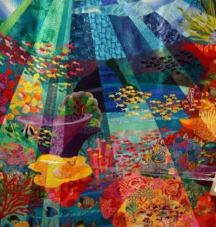 Colorful patchwork quilt with floral and geometric fabric patterns in vibrant hues