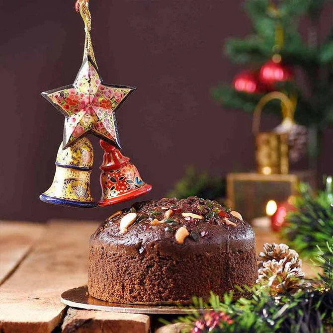 Festive fruit cake with Christmas ornaments and pine cones