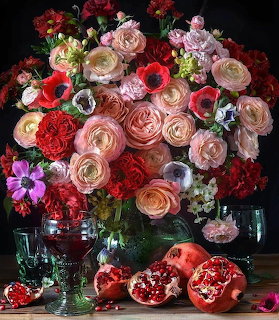 Colorful flower bouquet in vase with pomegranates on table