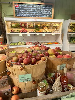 Wooden baskets of red and green apples in front of a market produce shelf