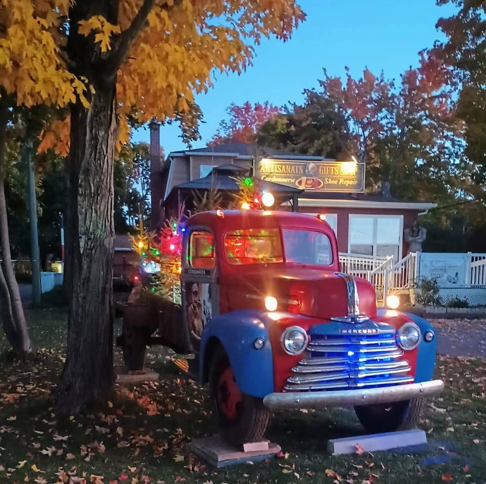 Vintage red and blue truck parked beside autumn trees at dusk