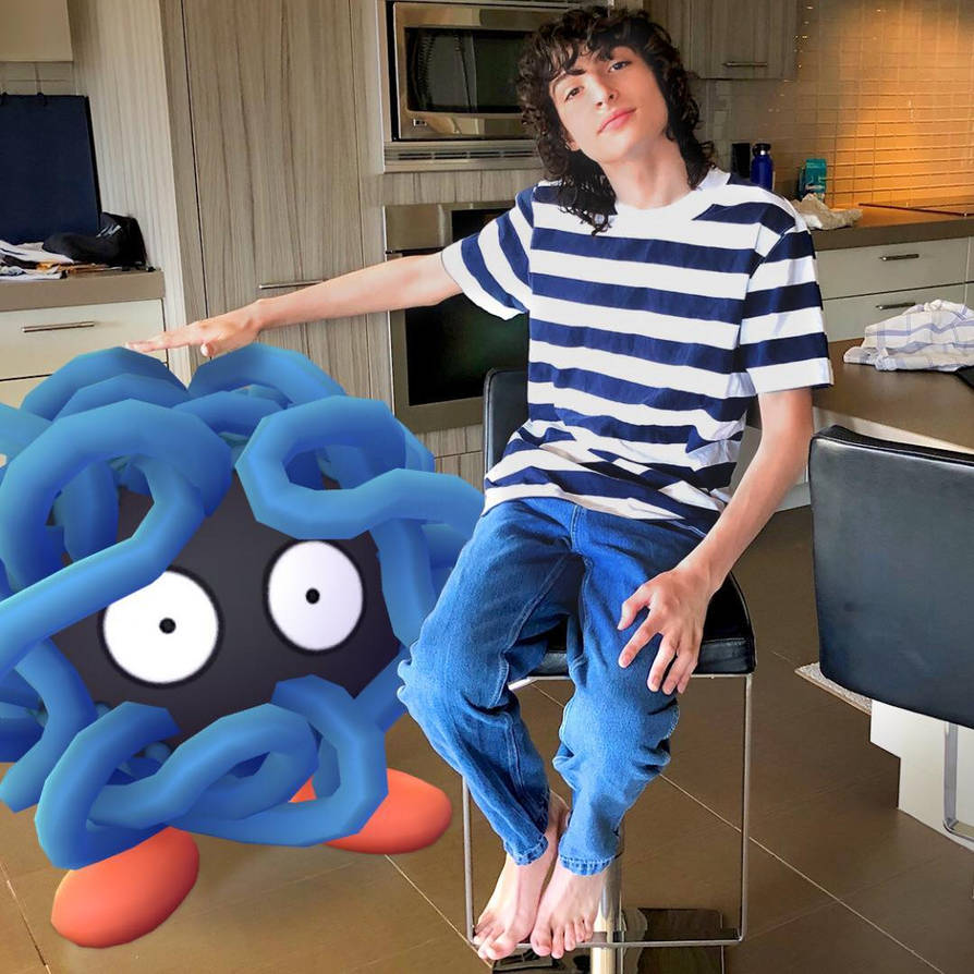 Young man in blue and white striped shirt sitting on kitchen counter with blue sculpture