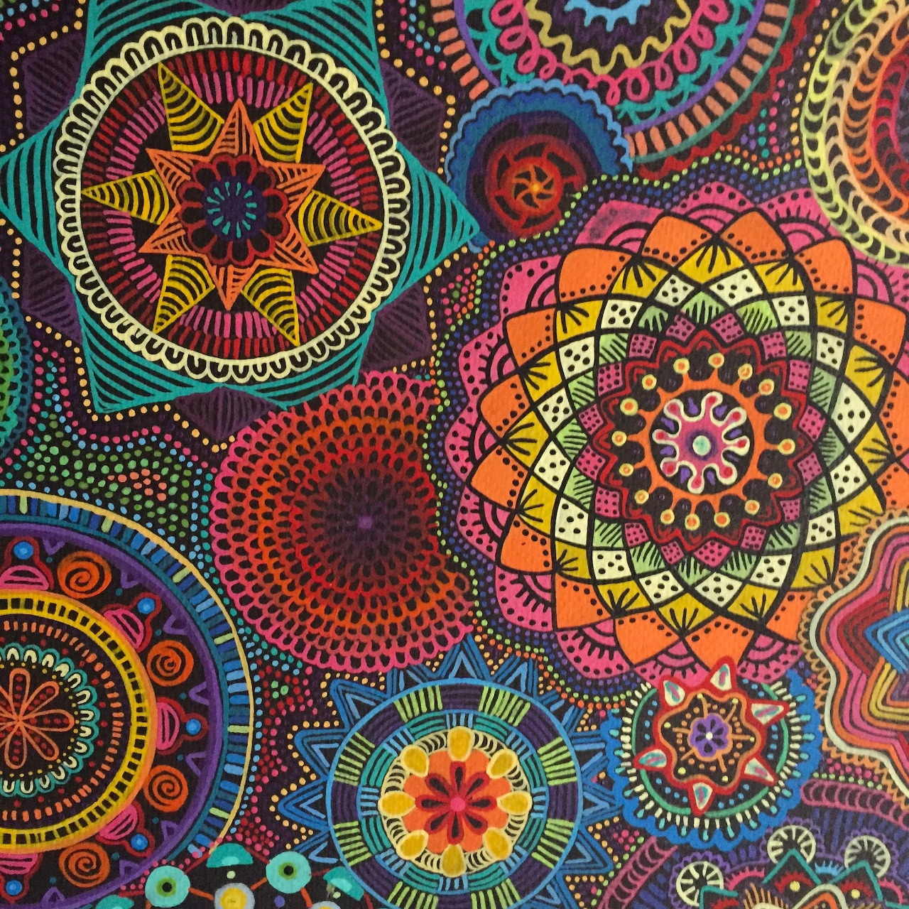 Multiple colorful mandala designs with geometric patterns on black background