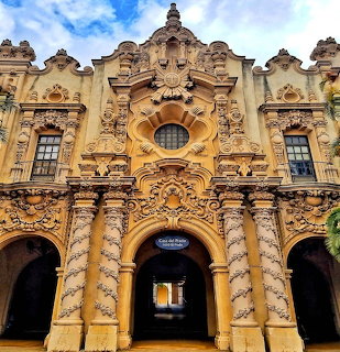 Ornate historic facade of Casa Del Prado with carved stonework, columns, and arched entrances