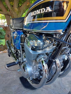 Close-up of vintage Honda CB750 Four motorcycle engine with chrome exhaust and blue tank