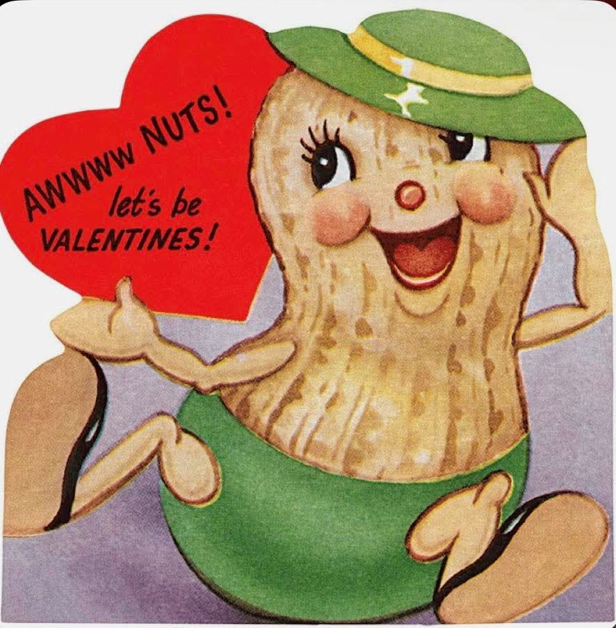 Smiling cartoon peanut character in green hat holding red Valentine heart with text