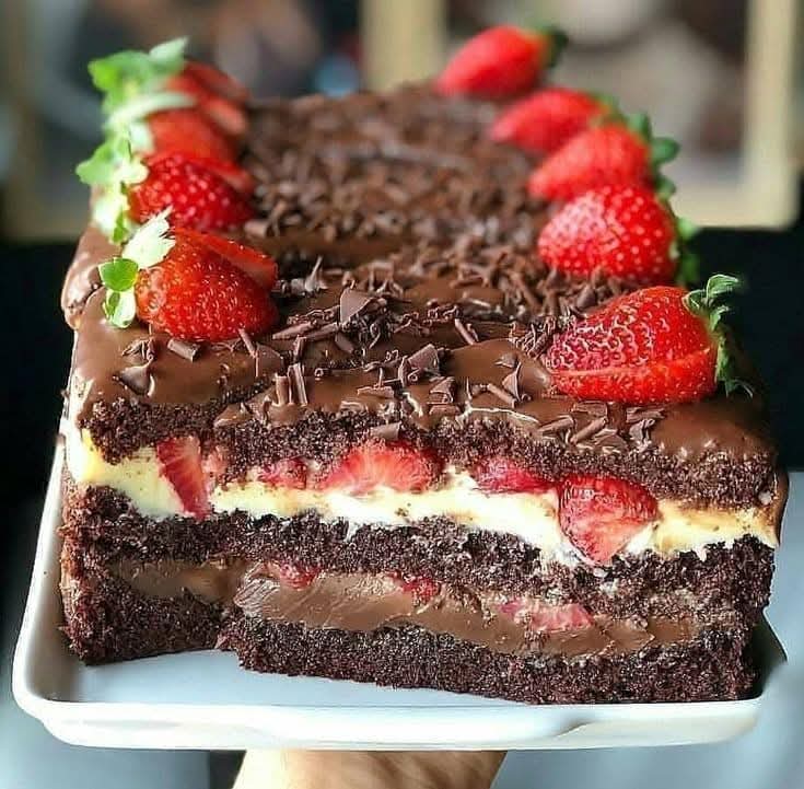 Chocolate layer cake topped with strawberries and chocolate shavings