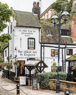 White historic English pub with black lanterns and ivy-covered walls
