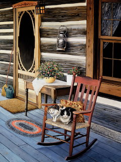 Two cats sitting on a wooden rocking chair on a rustic cabin front porch
