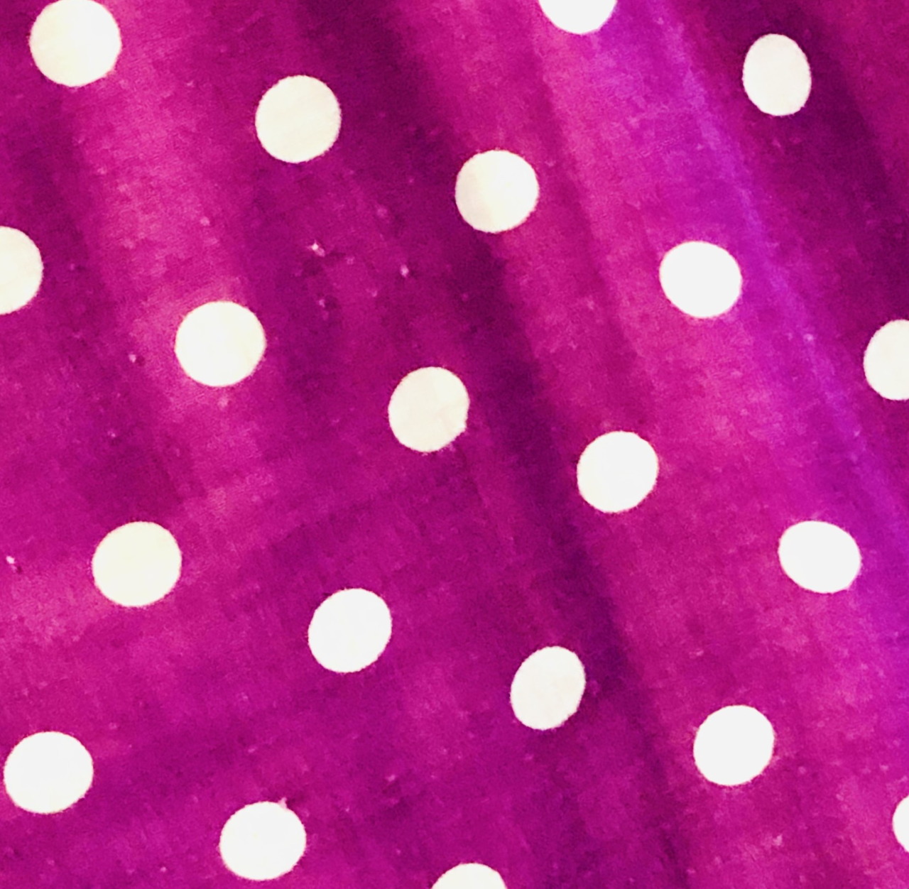 Magenta fabric with white polka dots and soft folds