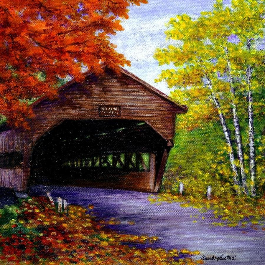 Wooden covered bridge with autumn trees in red and yellow colors on a rural road