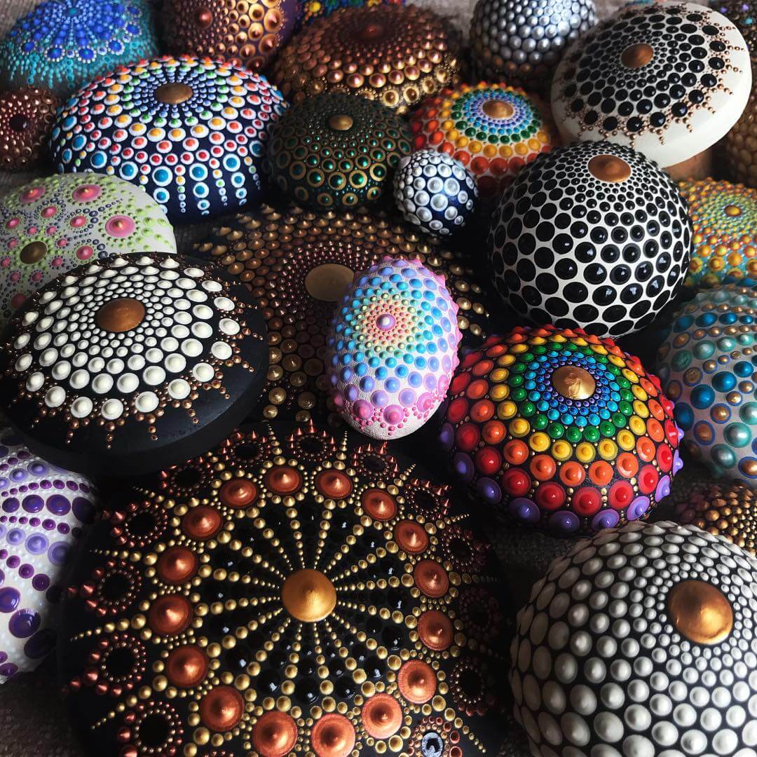 Colorful hand-painted pebbles with mandala dot art patterns arranged together