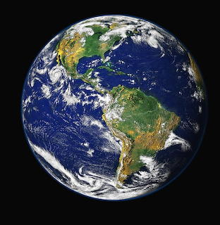 Satellite photograph of Earth from space showing North and South America, oceans, clouds, and continents