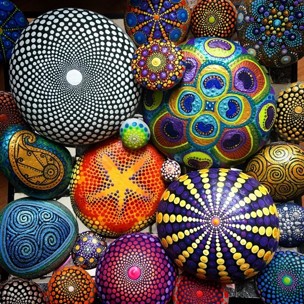 Colorful hand-painted mandala stones with dotted patterns and decorative pebble designs