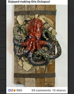 Colorful mosaic octopus sculpture with red body and green tentacles on a rustic wood and stone panel