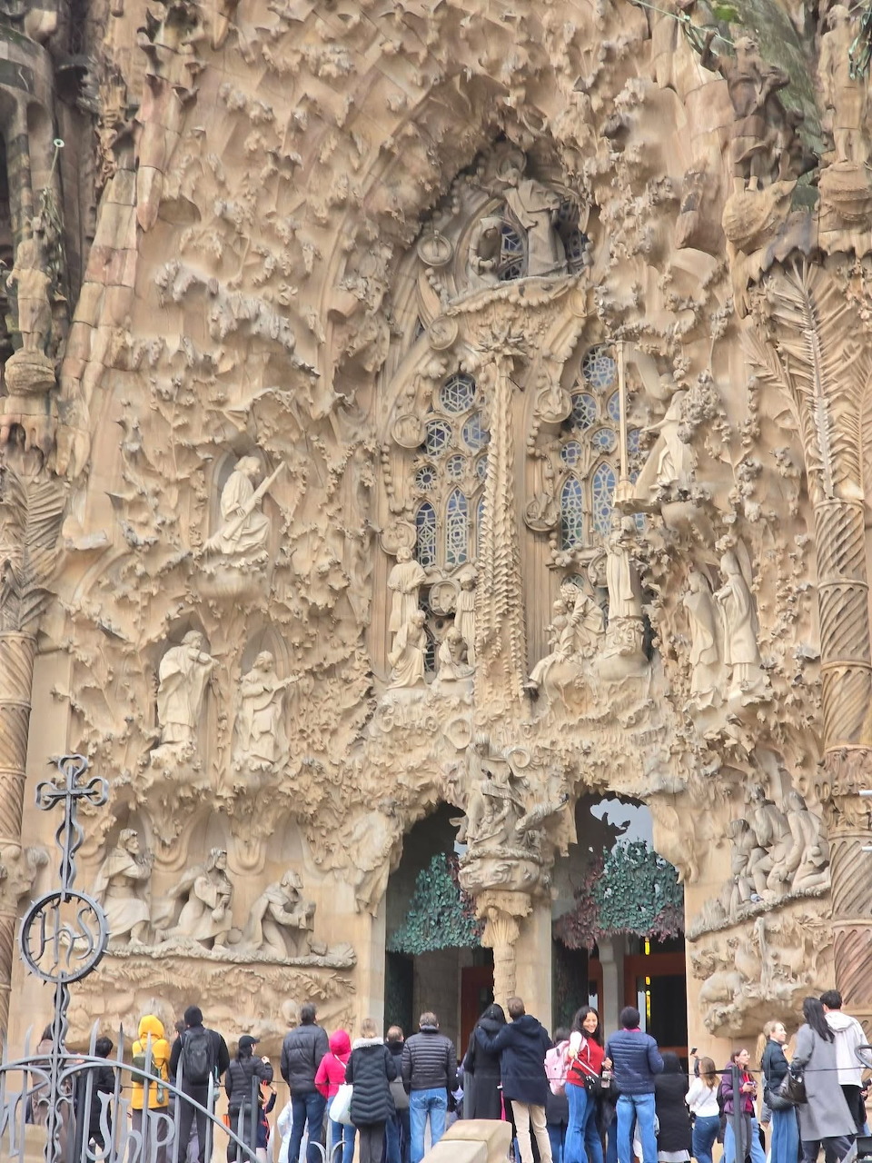 People at the sculpted stone facade of the Sagrada Familia in Barcelona