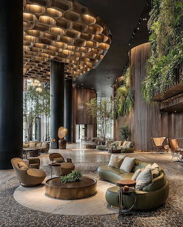 Modern luxury lobby with curved sofas, tall columns, wood walls, and hanging greenery