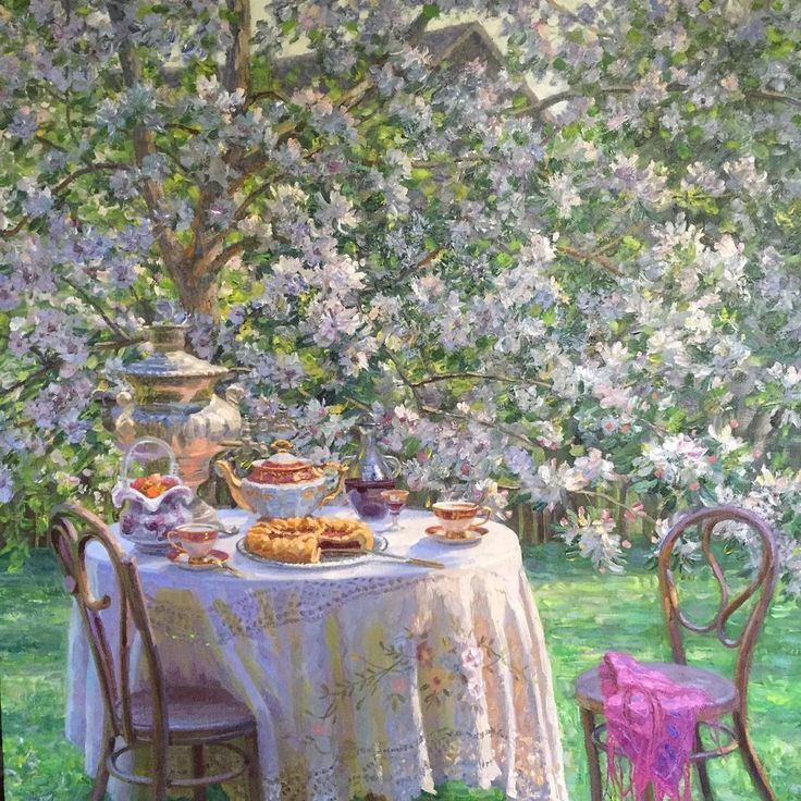 Picnic table with desserts and teapot under flowering trees in spring garden
