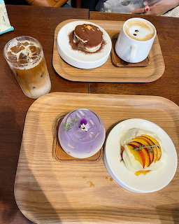 Overhead view of cafe table with desserts and coffee drinks on wooden trays