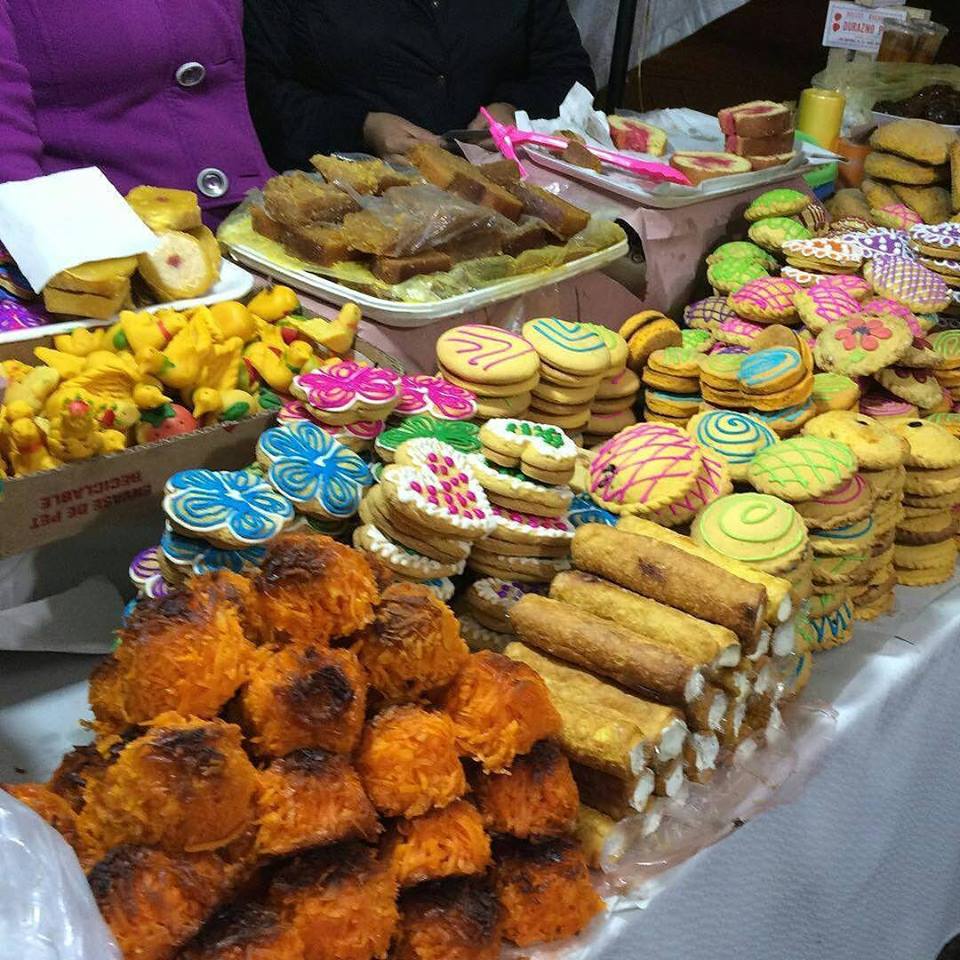 Colorful display of Mexican pastries and decorated cookies at a market stall