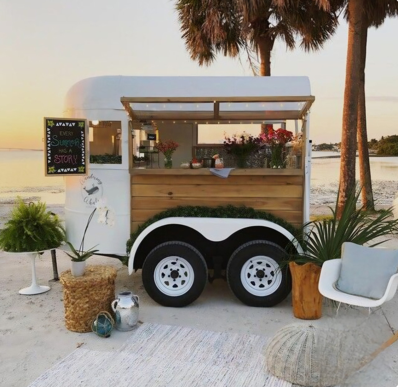 Wooden coffee cart trailer on beach at sunset with palm trees and tropical decor