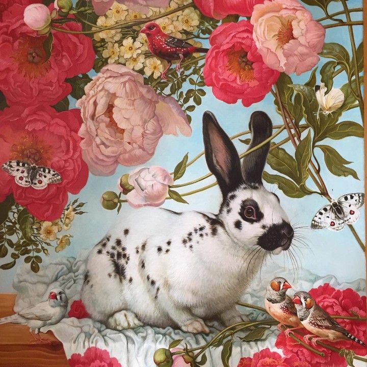 Spotted white rabbit in a floral painting with pink roses, small birds, and butterflies