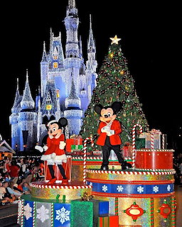 Mickey and Minnie Mouse in holiday costumes with decorated castle and Christmas tree behind them
