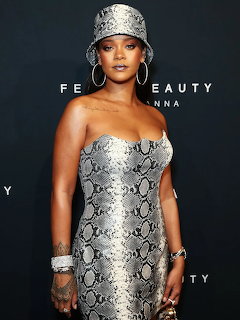 Rihanna in strapless snakeskin-print gown with silver accessories and large hoop earrings