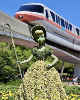 Bo Peep topiary in yellow flower dress with Disney monorail in background