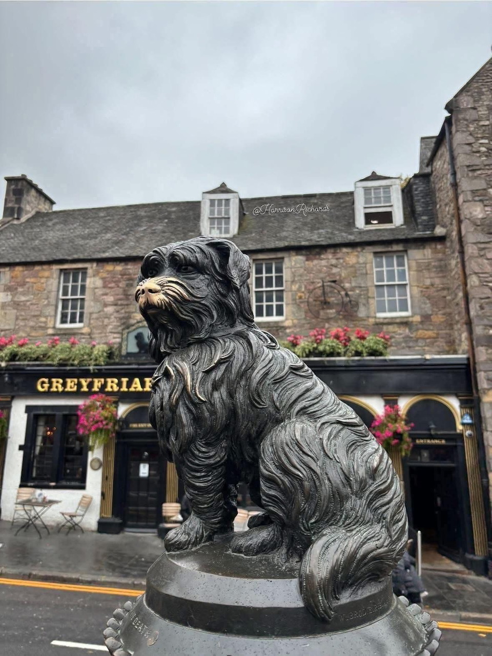 Bronze statue of Greyfriars Bobby dog in front of the Greyfriars pub in Edinburgh