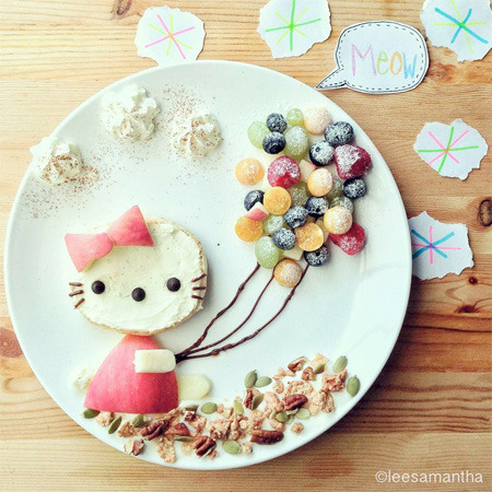 Hello Kitty character made from food with fruit balloon skewers on white plate