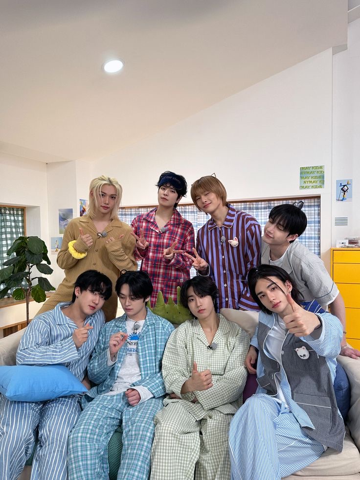 Group of eight people in pajamas posing together in a bright indoor room