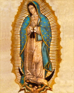 Religious painting of Our Lady of Guadalupe with folded hands and a blue star-covered mantle