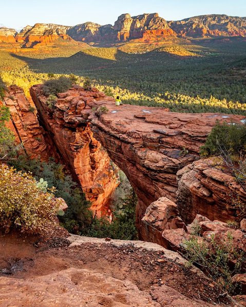 Red rock formations at sunset overlooking desert valley with mountains