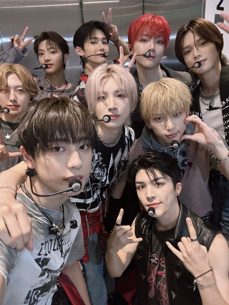 K-pop boy group &TEAM members posing together in stylish outfits