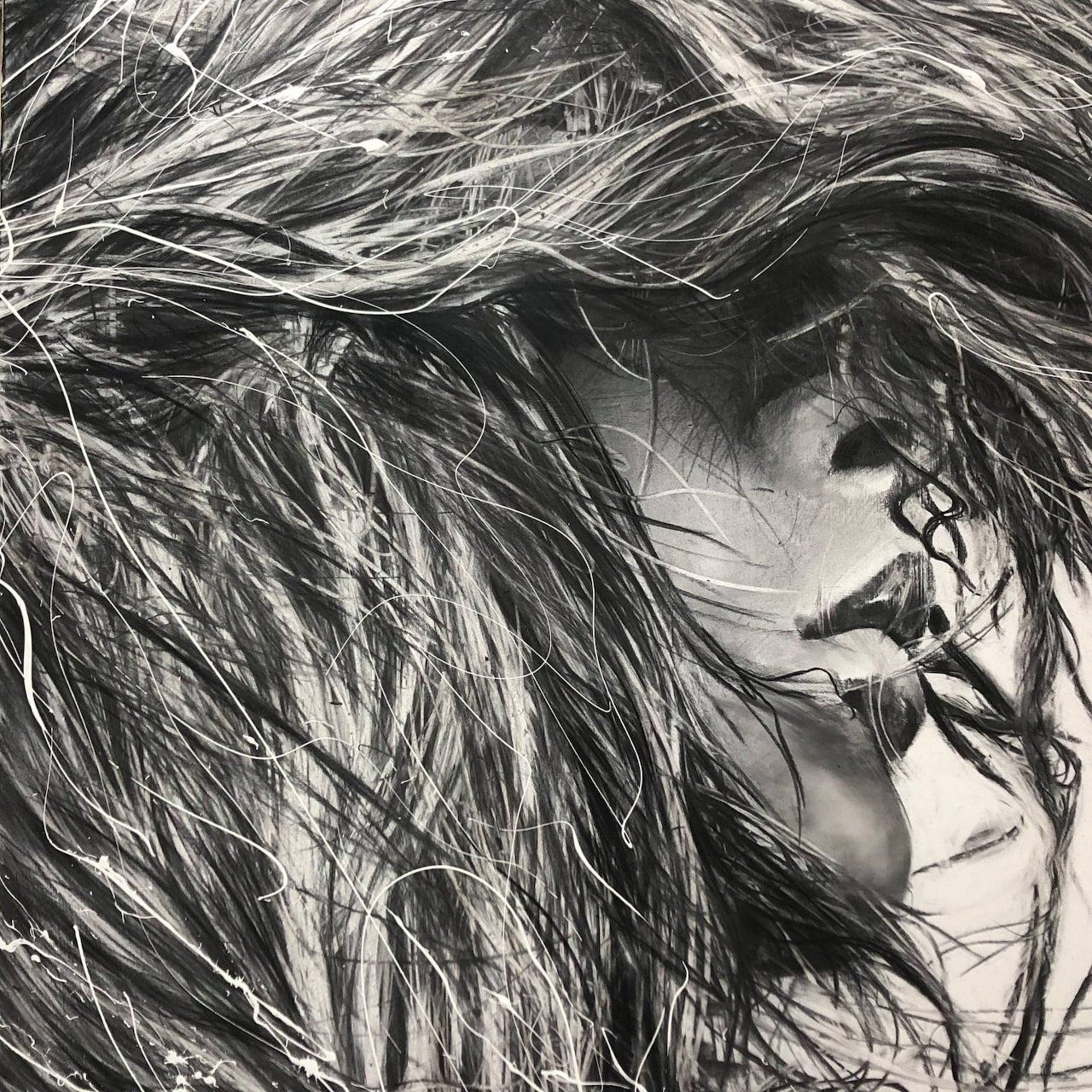 Black and white portrait of woman in profile with flowing hair and face decoration