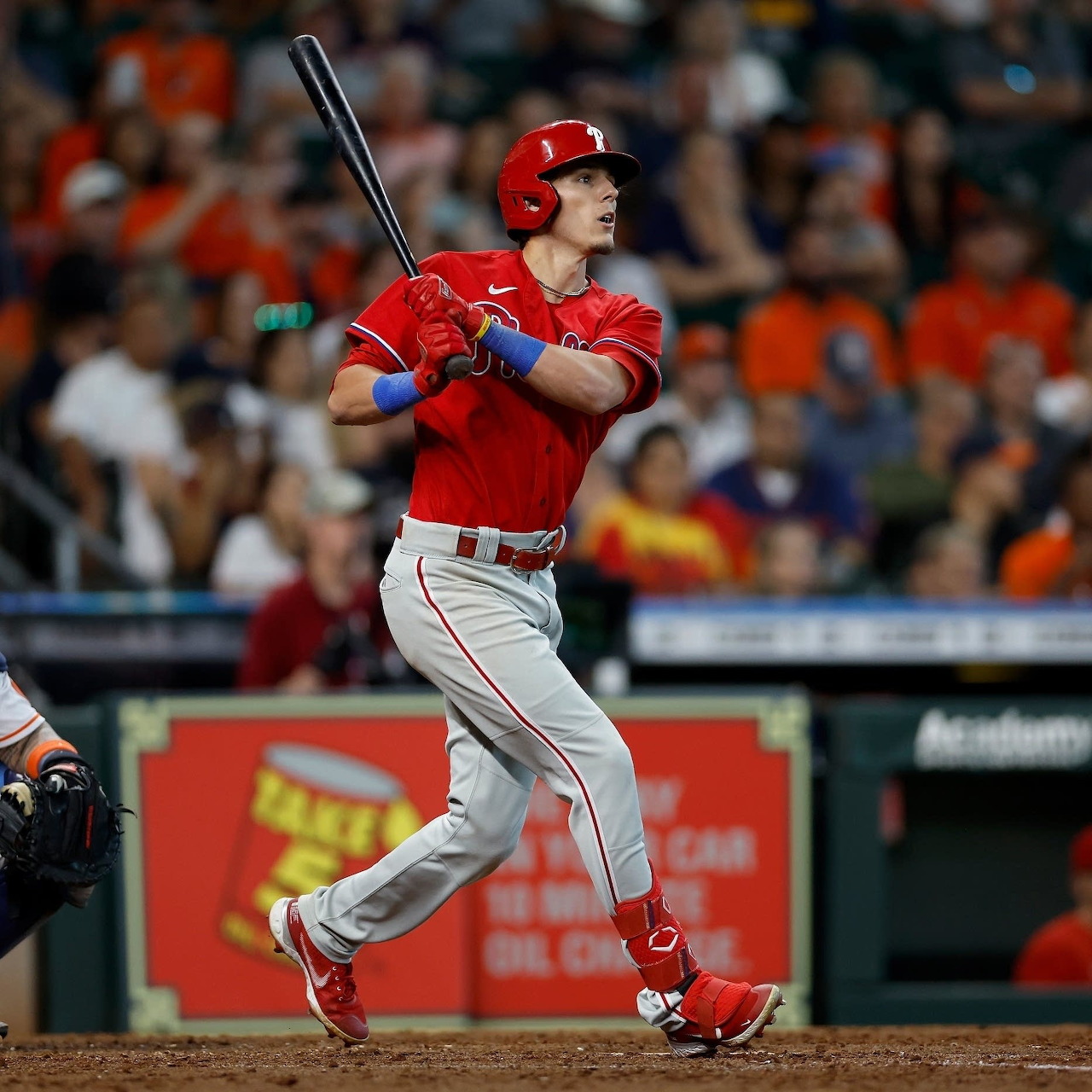 Baseball player in a red uniform swinging a bat during a game