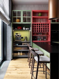 Modern kitchen with colorful cabinets, mint countertop, red wine storage, and wood floor