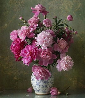 Bouquet of pink peonies in a blue and white porcelain vase on a table