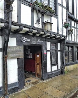 Black Swan pub with Tudor timber framing and flower baskets in York, England