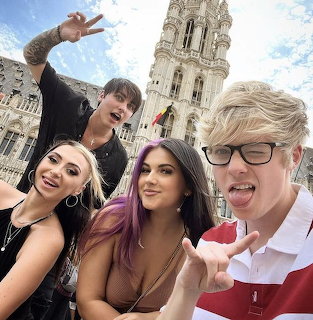 Four friends taking selfie with Brussels Town Hall Gothic tower in background