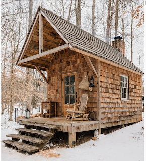 Small wooden cabin in a snowy forest landscape during winter