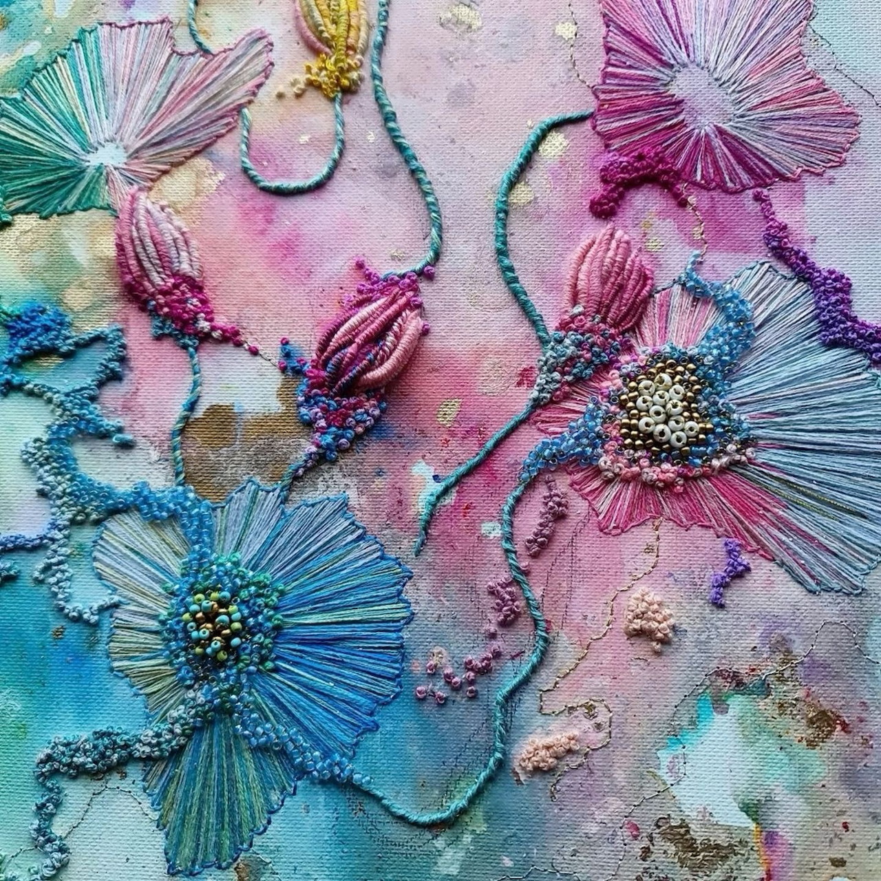 Mixed media floral art with embroidered flowers, beads, and fabric petals on watercolor background