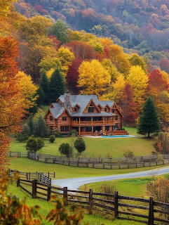 Rustic log cabin with multiple levels nestled among colorful autumn trees on a green hillside with split-rail fence