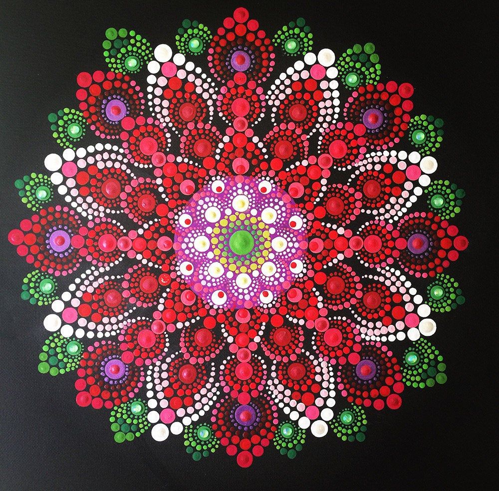 Colorful dot mandala with red flower petals radiating from a bright center on black background